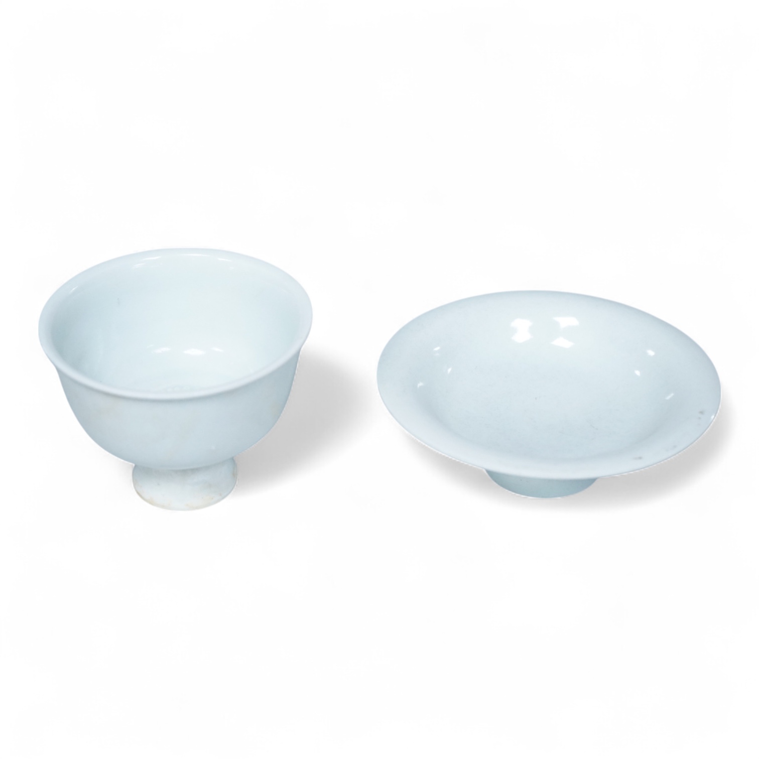 A Chinese white glazed stem cup and similar dish, tallest 7cm